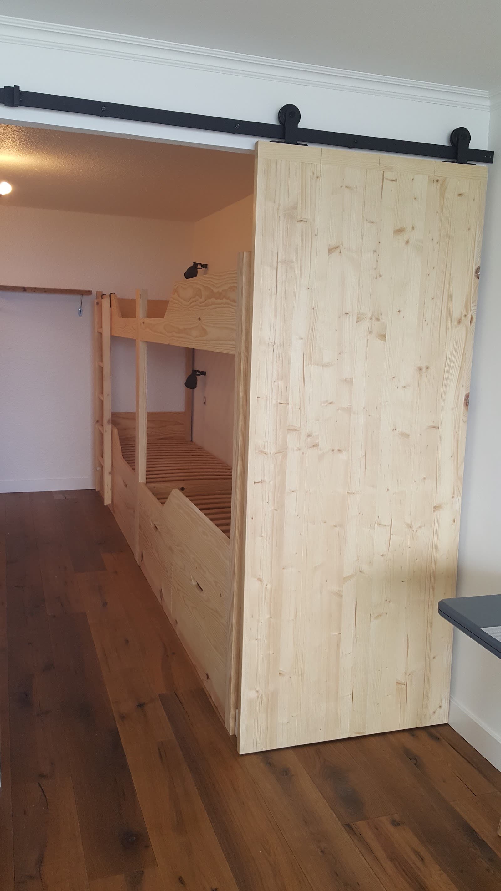 Lit superposé et grande porte coulissante en bois clair fabriqués pour une chambre