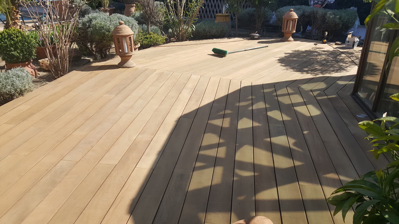Terrasse extérieure en lames de bois posées dans un jardin méditerranéen